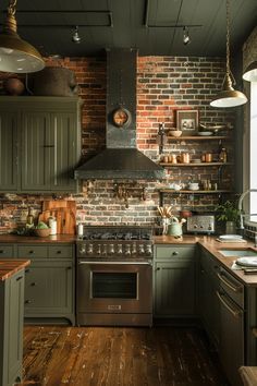 a kitchen with green cabinets and wood floors, an oven, sink, stove hood and window