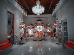 a man sitting in the middle of a room with chandelier and other decorations