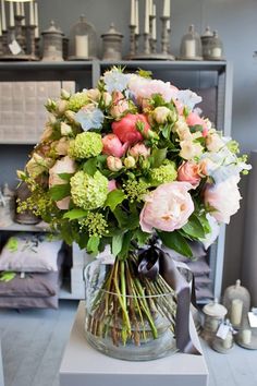 a vase filled with lots of flowers on top of a table