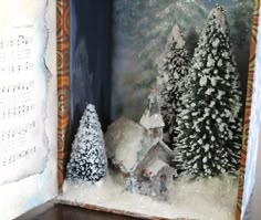 an open book with snow covered trees and sheet music