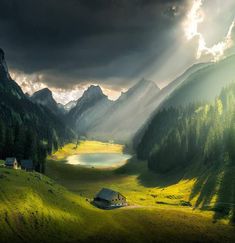 the sun shines down on a mountain valley with a lake in the foreground