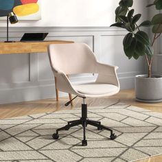 a white office chair sitting on top of a wooden floor next to a potted plant