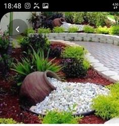 a brick walkway surrounded by plants and rocks