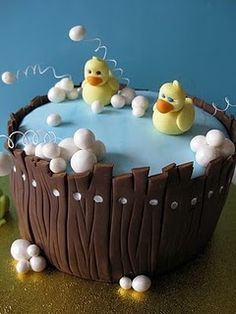 there is a cake that has two ducks in the tub on it and bubbles floating around