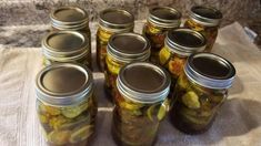 several jars filled with pickles sitting on top of a table