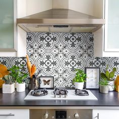 a stove top oven sitting inside of a kitchen next to a wall mounted range hood