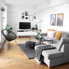 a living room filled with furniture and a flat screen tv on top of a wooden floor