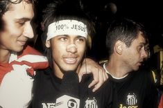 two men with headbands on standing next to each other in front of another man