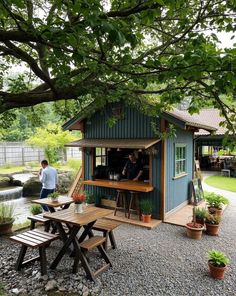 a small blue shed sitting next to a tree