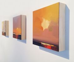 three paintings are hanging on the wall next to each other, one is orange and yellow