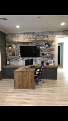 a home office with brick wall and desk