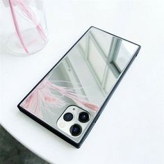 an image of a cell phone on a table with its reflection in the back cover