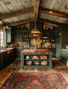 a large kitchen with green cabinets and wooden floors, along with a rug on the floor