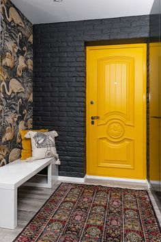 a yellow door is in the corner of a room with black walls and rugs