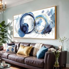 a living room with a couch, coffee table and large painting on the wall above it