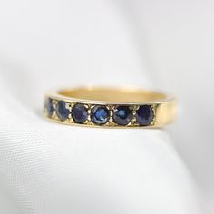 "Stunning sapphire half eternity ring. Wide and full of presence and set with beautiful natural gemstones. Handmade by an inspired jewelry artist team with decades of experience in the craft of jewelry making. Each gemstone, each diamond is carefully picked. Using only the finest raw materials and the highest industry standard in manufacturing, design and finish. Ring Features: Set with 2.75 mm round facet cut Natural Sapphires with a perfect deep Medium-blue color. This eternity ring is 3.5mm w Fine Jewelry Sapphire Half Eternity Ring, Sapphire Half Eternity Ring For Anniversary, Channel Set Sapphire Jewelry, Channel Set Sapphire Ring For Anniversary, Gold Sapphire Half Eternity Ring, Sapphire Ring Channel Set As Gift, Sapphire Anniversary Ring Channel Set, Lab-created Sapphire Ring With Channel Set, Sapphire Round Cut Half Eternity Ring