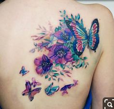 a woman's back with butterflies and flowers on it