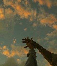 two people reaching up into the sky with their hands