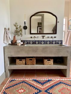 a bathroom with a sink, mirror and rug