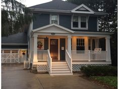 a white house with blue siding and porch