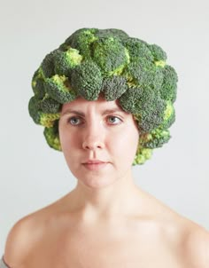 a woman with a head made of broccoli on her head is staring at the camera