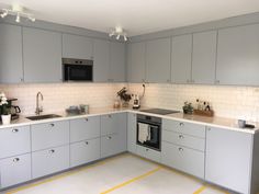 a kitchen with gray cabinets and yellow lines on the floor