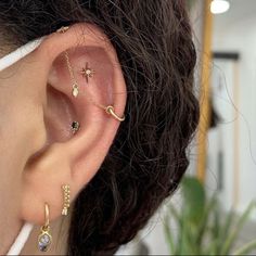 a woman's ear with three different piercings