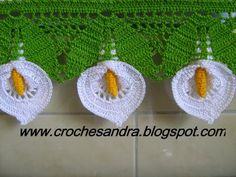 three crocheted doily hanging on a tile wall with yellow flowers in the center