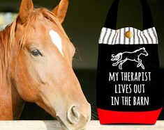 a brown horse standing next to a black and white bag with the words, my therapist lives out in the barn