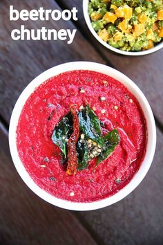 two bowls filled with beetroot chutney on top of a wooden table