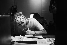 a man sitting at a desk writing on a piece of paper