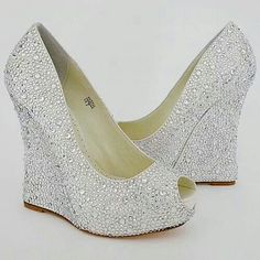 a pair of white high heeled shoes with silver glitters on the bottom and sides