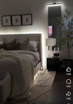 a large bed sitting in a bedroom next to a night stand with lights on it