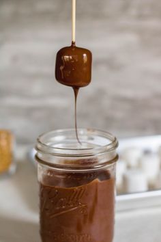 a jar filled with melted chocolate on top of a counter