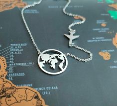 "Amazing world globe necklace which will make a perfect gift for travellers.  This Earth necklace is a great reminder of how big the world is and how many places you still have to visit or you have been already. Small airplane charm have been added to create this perfect travel gift.  ✽ Diameter of the Globe Pendant: 2 cm =slightly smaller than 1\"  All my jewellery is lead and nickle free. I am attaching the globe and airplane charms on silver plated chains, which I cut to size to create something pretty just for you.  ✽ ENVIRONMENTAL FRIENDLY PACKAGE I was always feeling bad for creating more waste on this planet so I try to be environmental friendly everywhere where possible. All my wrapping material is biodegradable and recyclable :) My jewelry comes on A6 designed paper in a biodegrad Travel Stainless Steel Silver Necklaces, Travel Silver Stainless Steel Jewelry, Personalized Pendant Necklaces For Travel, Sterling Silver Necklace With Round Pendant For Travel, Necklace Airplane, Earth Necklace, Globe Necklace, Airplane Necklace, Designed Paper