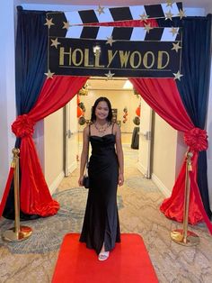 a woman standing in front of a hollywood sign at the entrance to a hotel lobby