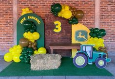 a tractor themed birthday party with balloons, hay bales and balloon decorations on the ground