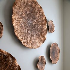 three pieces of wood sitting on top of a white wall next to other wooden objects