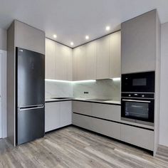 an empty kitchen with stainless steel appliances and wood flooring is pictured in this image