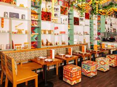 the interior of a brightly colored restaurant with wooden tables and chairs