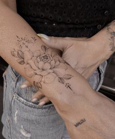 a woman's arm with a flower tattoo on it