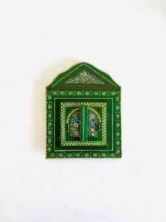 a green and white wall hanging with a window