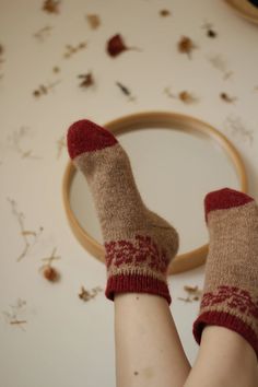 a woman's legs with red socks and woolen socks in front of a mirror