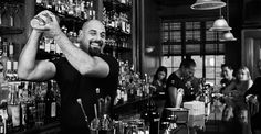 a man standing in front of a bar filled with bottles