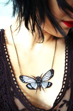 a woman wearing a black and white butterfly necklace