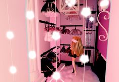 a woman standing in front of a pink closet filled with clothes and lights on the walls