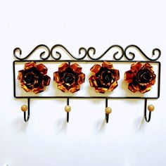 three orange flowers are hanging from a metal rack