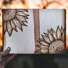 someone holding up a book with sunflowers on it