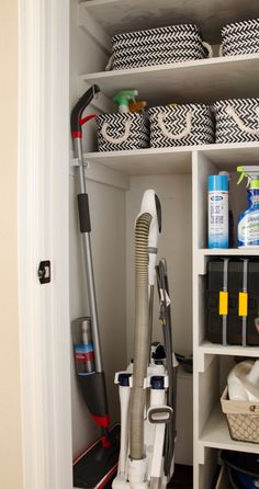 the closet is filled with cleaning supplies and other household items, including a vacuum cleaner