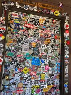 a door covered in lots of stickers and decals on the side of a building